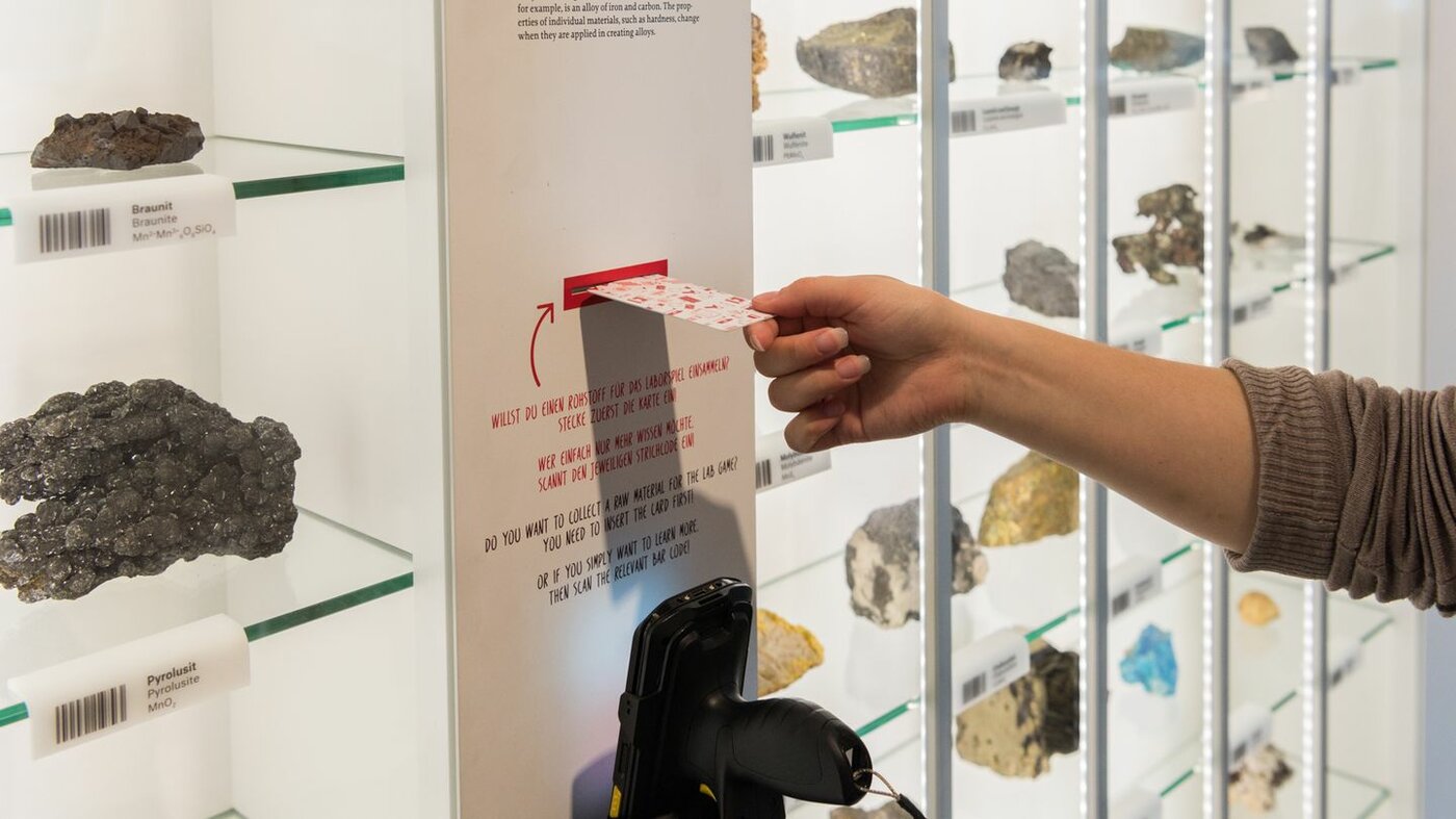 Eindruck des Rundgangs "Bodenschätze" Interaktive Vitrine, die verschiedene Mineralien zeigt, an der ein Scanner befestigt ist sowie ein Eingabeslot, in den man eine Karte für ein Spiel stecken kann